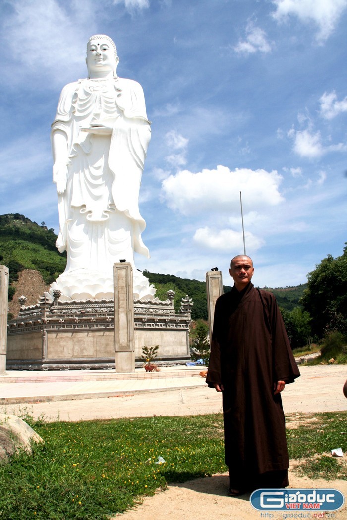 Đại đức Thích Minh Huy bên tượng phật Di Đà được xem là cao nhất VN hiện nay.